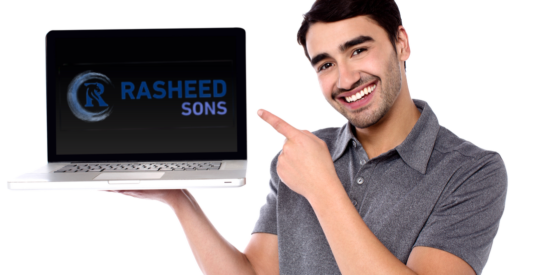 A smiling man holding and gesturing towards a cheap laptop South Africa, suggesting affordable deals.