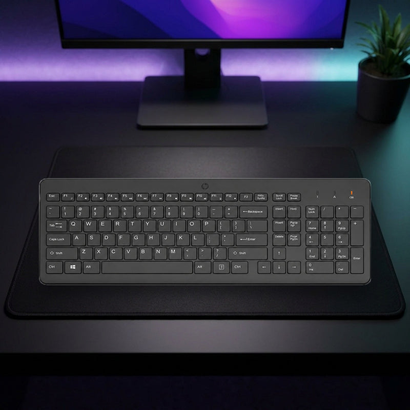 Lifestyle: HP 225 Wireless Full-Size Keyboard – 2.4GHz USB – Black shown on a styled desk (actual product photo, room is illustrative)