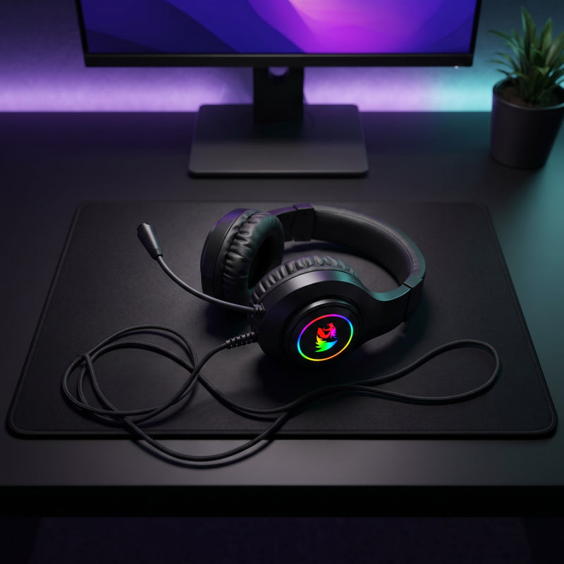 Lifestyle: Redragon H260 Hylas RGB Wired Gaming Headset | 50mm Drivers | Noise Isolating | PC & Console | Black on a desk (illustrative image; the first photo shows the actual product)