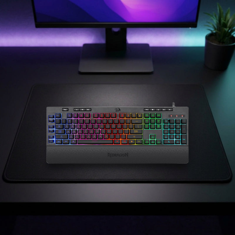 Lifestyle: Redragon K512 Shiva RGB Membrane Gaming Keyboard | Full-Size 104 Keys | 6 Macro Keys | Detachable Wrist Rest | Black shown on a styled desk (actual product photo, room is illustrative)